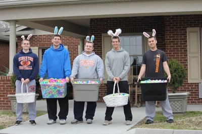 Young men wear bunny ears and carry Easter egg baskets