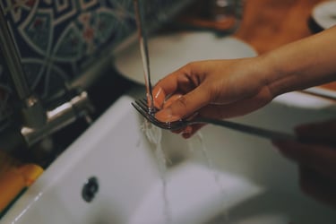 Image of hands washing a spoon