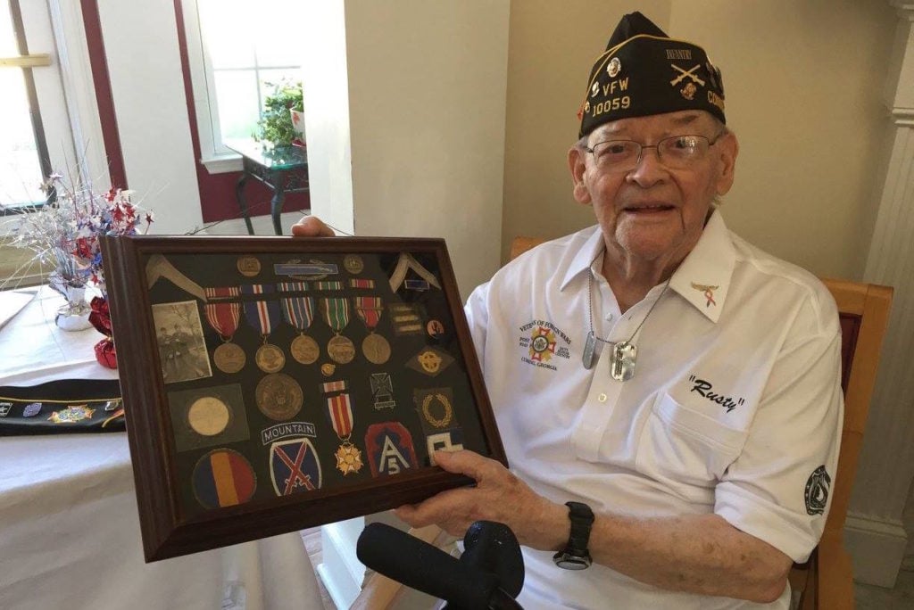 Image of elderly veteran holding medals