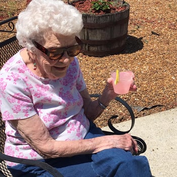 Elderly resident enjoys a lemonade in the outdoors at nursing home