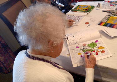 Senior living resident participating in adult coloring activities