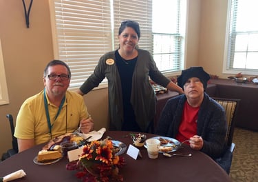 Senior Living staff member with residents in dining hall