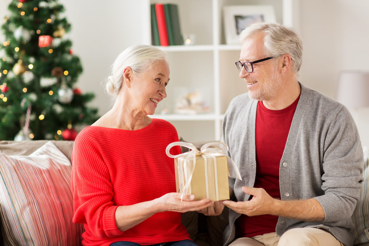 happy-smiling-senior-couple-with-christmas-gift-PWHAZME (1)