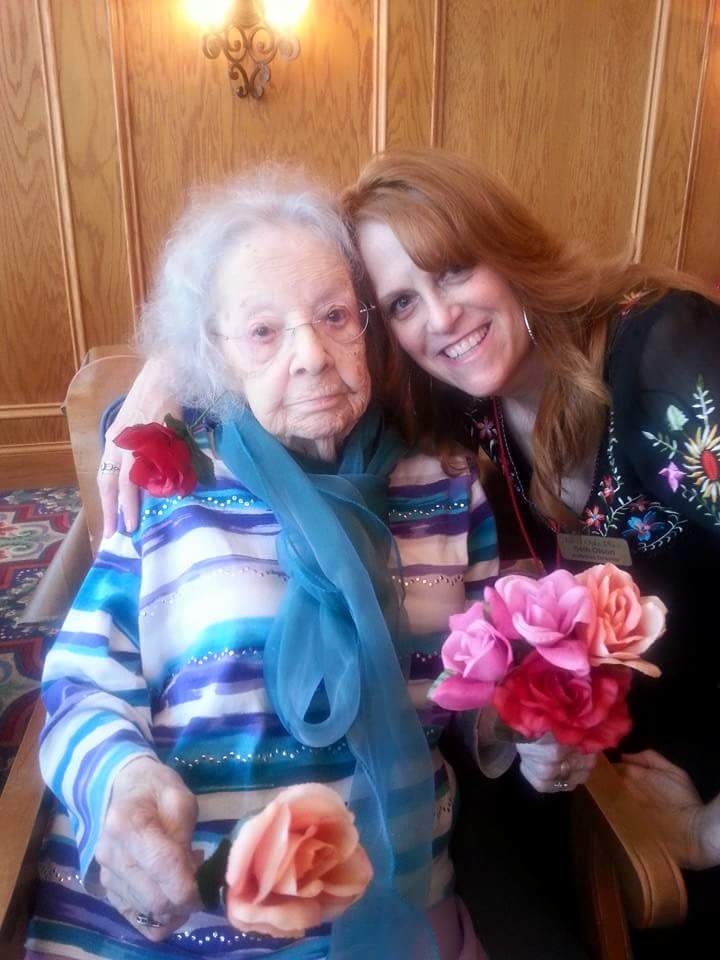Resident and Caregiver Holding Flowers